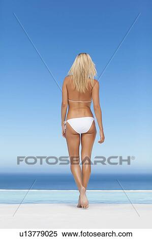 Woman wearing bikini by infinity pool View Large Photo Image Stock Photography - Woman wearing bikini by infinity pool. Fotosearch