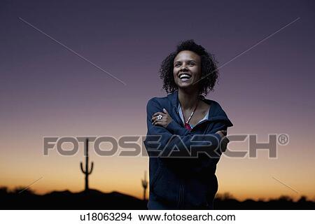 Picture - Woman wearing jacket in desert at night. Fotosearch