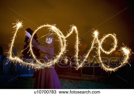 Woman writing LOVE with sparkler View Large Photo Image Stock Image - Woman writing LOVE with sparkler. Fotosearch