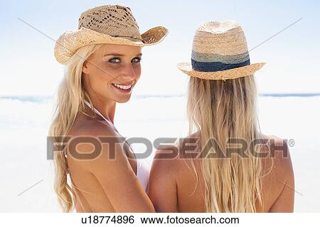 Stock Photograph - Women standing together on beach. Fotosearch