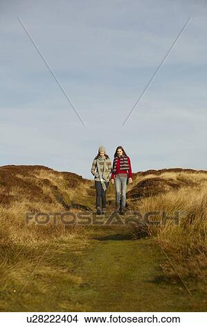 Women walking together on dirt path View Large Photo Image Picture - Women walking together on dirt path. Fotosearch