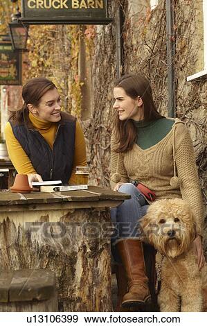 Women with dog having beer at cafe View Large Photo Image Stock Photo - Women with dog having beer at cafe. Fotosearch