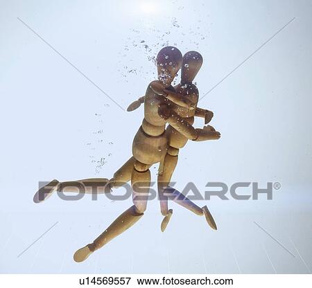 Wooden figurines hugging in water View Large Photo Image Stock Photo - Wooden figurines hugging in water. Fotosearch