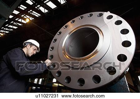 Worker examining metal in steel forge View Large Photo Image Stock Image - Worker examining metal in steel forge. Fotosearch