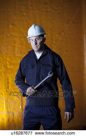 Stock Photo - Worker holding wrench in steel forge. Fotosearch