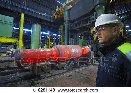 Worker standing in steel forge View Large Photo Image Stock Photo - Worker standing in steel forge. Fotosearch