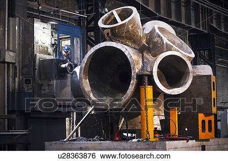 Worker using machinery in steel forge View Large Photo Image Stock Photograph - Worker using machinery in steel forge. Fotosearch