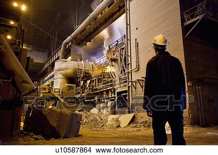 Picture - Worker walking in steel forge. Fotosearch