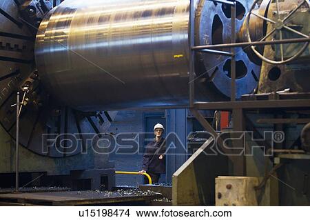 Worker with machinery in steel forge View Large Photo Image Picture - Worker with machinery in steel forge. Fotosearch