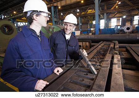 Workers examining metal in steel forge View Large Photo Image Stock Image - Workers examining metal in steel forge. Fotosearch