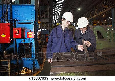 Workers examining metal in steel forge View Large Photo Image Stock Photo - Workers examining metal in steel forge. Fotosearch