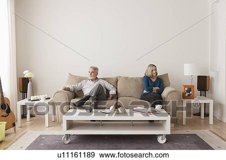 Angry senior couple sitting on sofa View Large Photo Image Stock Photo - Angry senior couple sitting on sofa. Fotosearch