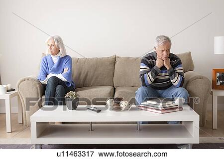 Angry senior couple sitting on sofa View Large Photo Image Stock Photo - Angry senior couple sitting on sofa. Fotosearch
