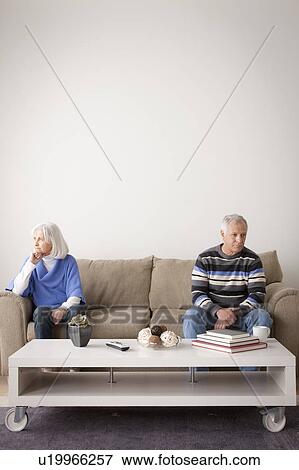 Angry senior couple sitting on sofa View Large Photo Image Stock Photo - Angry senior couple sitting on sofa. Fotosearch