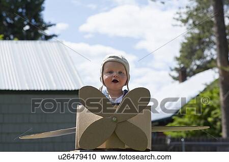 Baby boy (12-17 months) playing inside paper aeroplane made of cardboard box View Large Photo Image Stock Image - Baby boy (12-17 months) playing inside paper aeroplane made of cardboard box . Fotosearch