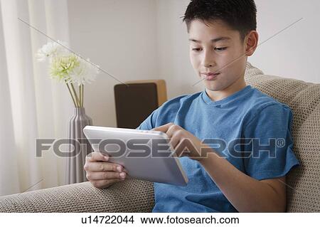 Boy (10-11) using digital tablet View Large Photo Image Picture - Boy (10-11) using digital tablet. Fotosearch