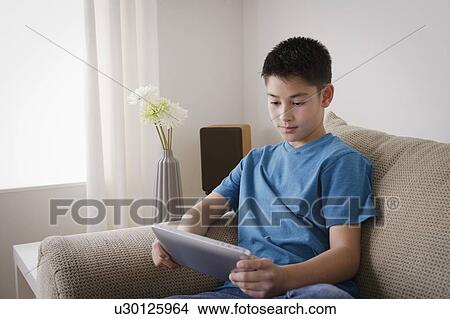 Boy (10-11) using digital tablet View Large Photo Image Picture - Boy (10-11) using digital tablet. Fotosearch