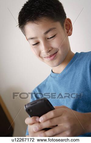 Boy (10-11) using mobile phone View Large Photo Image Stock Image - Boy (10-11) using mobile phone. Fotosearch