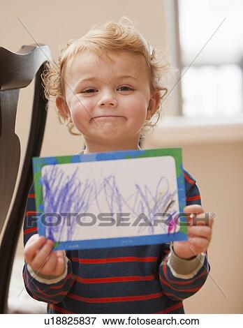 Boy (4-5) showing his drawing View Large Photo Image Stock Photo - Boy (4-5) showing his drawing. Fotosearch