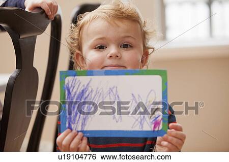 Boy (4-5) showing his drawing View Large Photo Image Stock Photograph - Boy (4-5) showing his drawing. Fotosearch