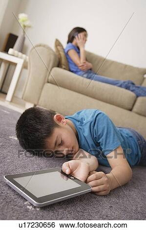 Boy sleeping on floor with iPad in hand View Large Photo Image Stock Photograph - Boy sleeping on floor with iPad in hand. Fotosearch
