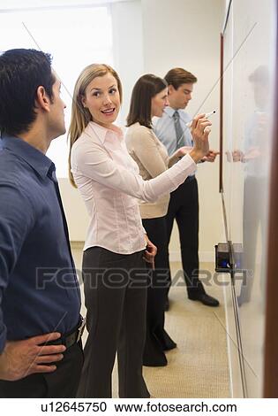 Business people writing at whiteboard View Large Photo Image Stock Image - Business people writing at whiteboard. Fotosearch