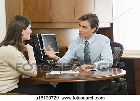 Stock Photo - Businessman and client talking in office. Fotosearch