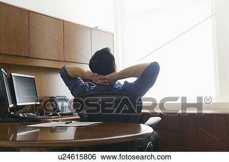 Businessman sitting in office View Large Photo Image Stock Photograph - Businessman sitting in office. Fotosearch