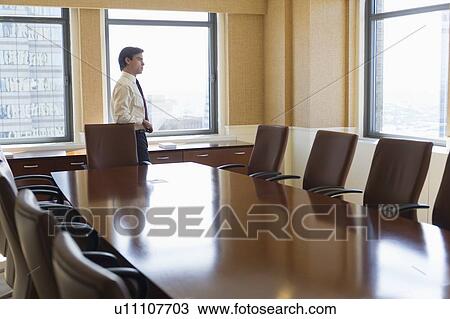 Stock Image - Businessman standing in board room. Fotosearch