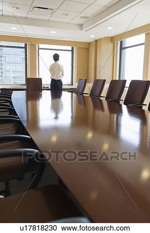Businessman standing in board room View Large Photo Image Stock Image - Businessman standing in board room. Fotosearch