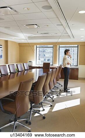 Businessman standing in board room View Large Photo Image Stock Photo - Businessman standing in board room. Fotosearch