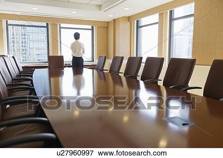 Stock Photo - Businessman standing in board room. Fotosearch