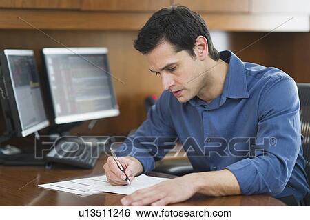 Businessman writing at desk View Large Photo Image Stock Photograph - Businessman writing at desk. Fotosearch