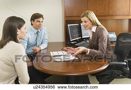 Businesswoman and clients talking in office View Large Photo Image Stock Photograph - Businesswoman and clients talking in office. Fotosearch