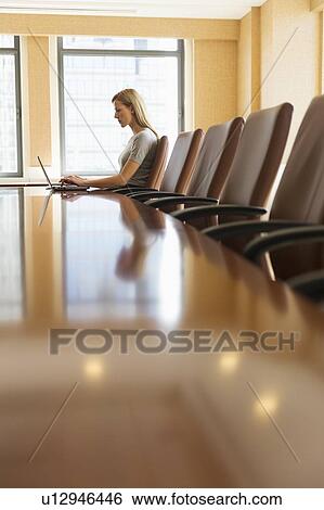 Stock Photograph - Businesswoman sitting in board room. Fotosearch