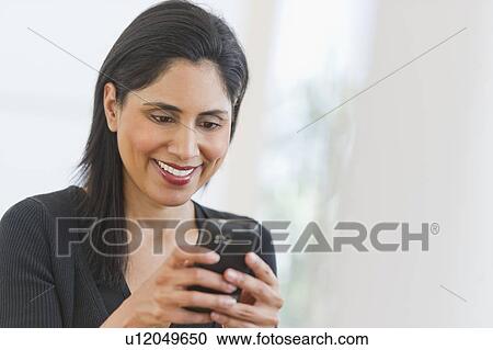Stock Image - Businesswoman text messaging. Fotosearch
