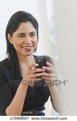 Stock Image - Businesswoman text messaging. Fotosearch