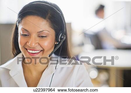 Businesswoman with headset, businessman in background View Large Photo Image Picture - Businesswoman with headset, businessman in background. Fotosearch