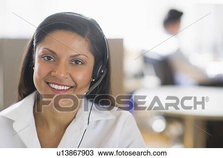Businesswoman with headset, businessman in background View Large Photo Image Stock Image - Businesswoman with headset, businessman in background. Fotosearch