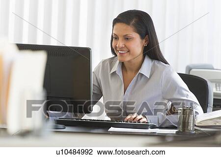 Businesswoman working on computer View Large Photo Image Stock Image - Businesswoman working on computer. Fotosearch