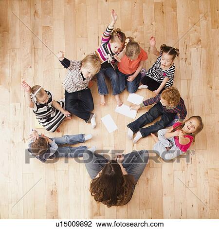 Children (2-3, 4-5) sitting on floor and raising hands, directly above View Large Photo Image Stock Image - Children (2-3, 4-5) sitting on floor and raising hands, directly above. Fotosearch