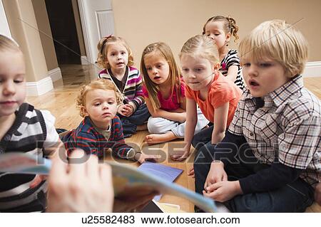 Stock Image - Children (2-3, 4-5) sitting on floor and learning. Fotosearch