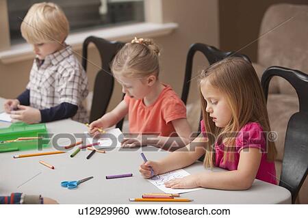 Stock Image - Children (4-5) drawing in kindergarten. Fotosearch