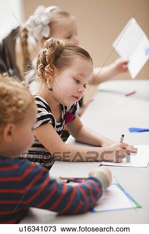 Stock Image - Children (4-5) drawing in kindergarten. Fotosearch