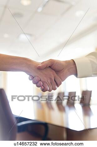 Stock Image - Close-up of business man and woman shaking hands. Fotosearch