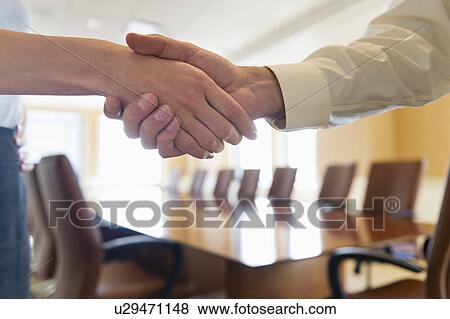 Stock Photo - Close-up of business man and woman shaking hands. Fotosearch