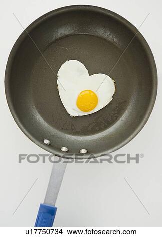 Close up of fried egg in heart shape on frying pan, studio shot View Large Photo Image Picture - Close up of fried egg in heart shape on frying pan, studio shot. Fotosearch