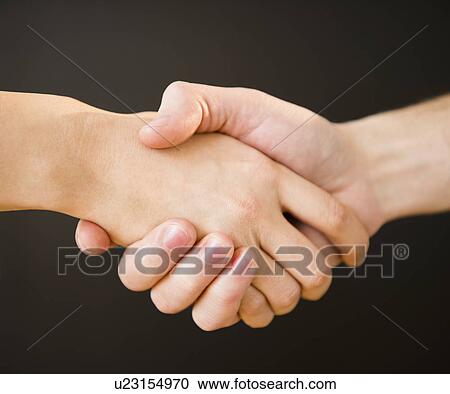 Stock Image - Close up of handshake, studio shot. Fotosearch