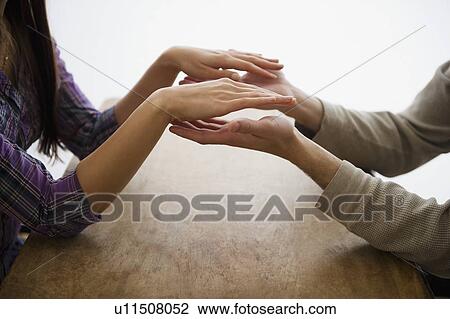 Stock Image - Close up of man's and woman's hands playing with hands. Fotosearch