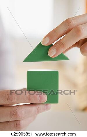 Stock Image - Close up of man's and woman's hands holding wooden blocks. Fotosearch